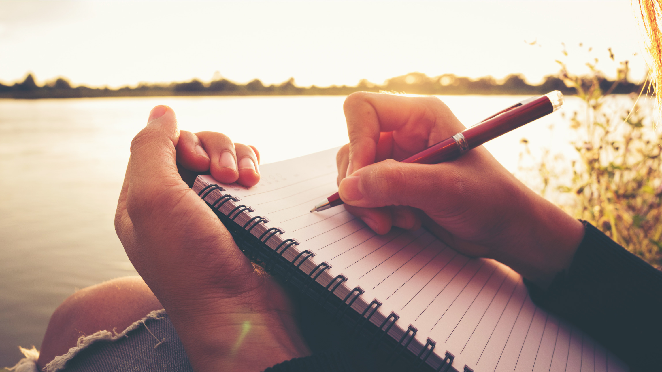 Photograph of hands writing in notebook
