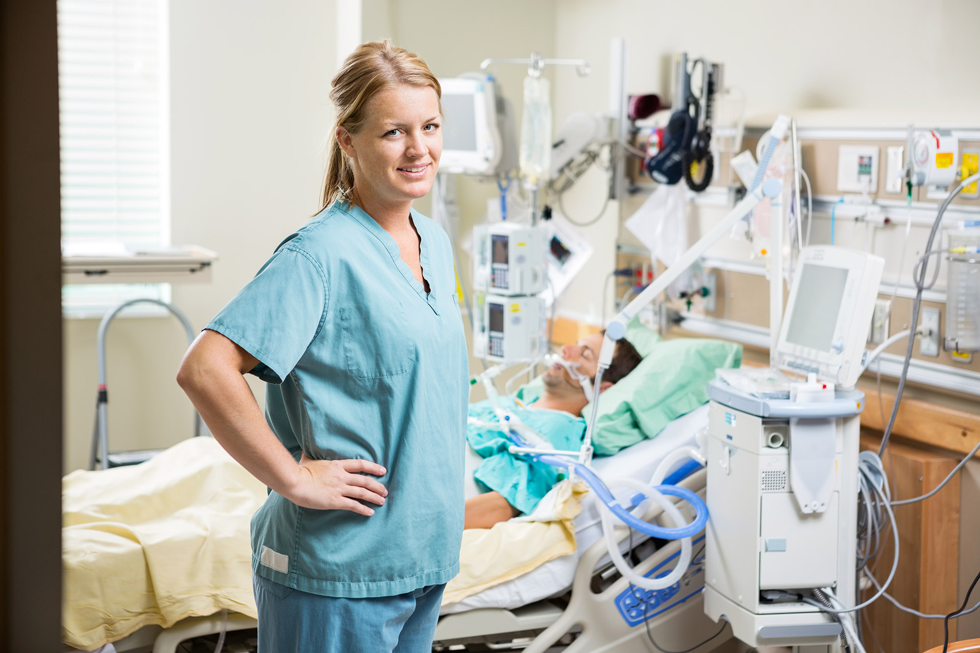 young smiling nurse at patient's bedside