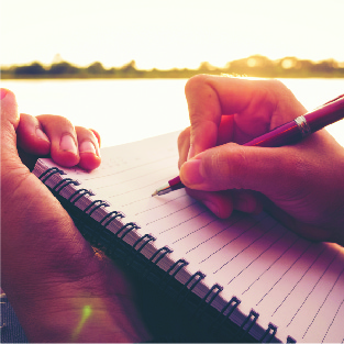 Photo of hands writing in journal
