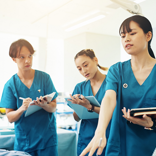 Nursing students listen to colleague in training lab